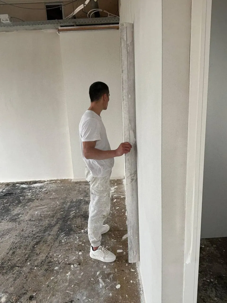 Stukadoor van Apeldoorn 4 Renovatie controleert een wand met een lange rei